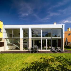 un grande edificio in vetro con sedie e tavoli su un prato di Outeiro Villas Resort a Barcelos Altre 37 foto
