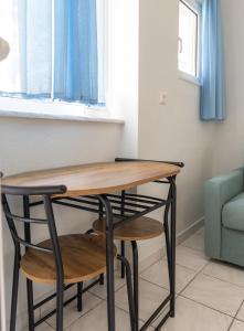einen Tisch und einen Stuhl in einem Zimmer mit Fenster in der Unterkunft Tropical Beach A1 in Kalamaki