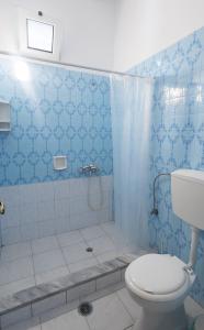 bagno blu con servizi igienici e doccia di Tropical Beach A1 a Kalamaki