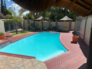 uma grande piscina azul num quintal em SiBella guest house em Bloemfontein