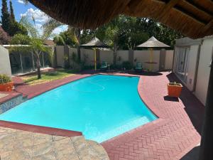 a large blue swimming pool in a yard at SiBella guest house in Bloemfontein