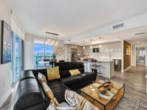 sala de estar con sofá negro y cocina en Luxury Waterfront Suite with Great Views en Hallandale Beach