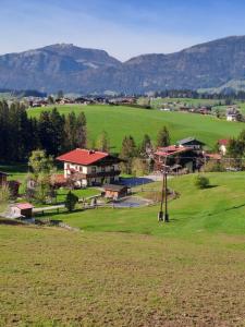 a small town with a field and mountains in the background at Haus Wallinger in Abtenau