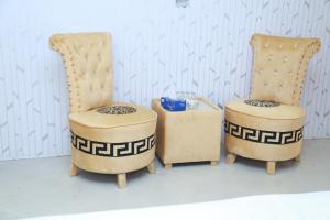 2 chaises et une table de chevet dans une pièce dans l'établissement Hotel palm east lahore, à Lahore