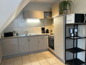 una cocina con armarios blancos y fregadero en Au Coeur des Collines, Gloriette, en Ellezelles