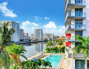 Una vista de un edificio con piscina y palmeras. en Luxury Waterfront Suite with Great Views, en Hallandale Beach