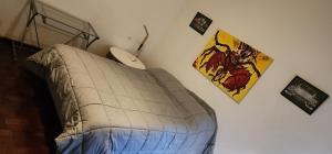 1 dormitorio con cama con edredón y ratón de ordenador en @embajadapichincha en Rosario