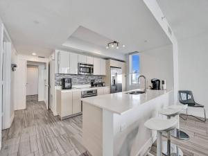 Una cocina con gabinetes blancos y encimera. en Luxury Waterfront Suite, en Hallandale Beach