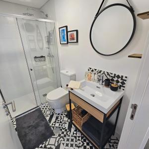 uma casa de banho com um WC, um lavatório e um espelho. em Grand Casa Vincente Suite-Near Sé Velha 7min away em Coimbra