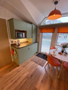 a kitchen and dining room with a table and chairs at Red Squirrel Lodge in Sandown