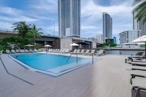 een zwembad met stoelen en een gebouw bij Luxury Waterfront Condo with Pool King Beds in Hallandale Beach