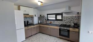 a kitchen with brown cabinets and a white refrigerator at La Coti in Braşov