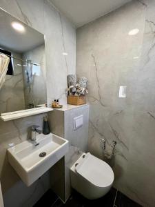 a bathroom with a white toilet and a sink at Sha Sho in Mostar