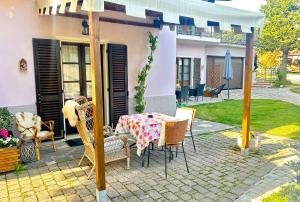 a patio with a table and chairs and a house at La Casa Di Campagna Sul Garda in Puegnano del Garda