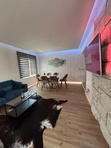 a living room with a blue couch and a tv at Daphne Luxe Retreat -Sea View-King size bed- in Supetar