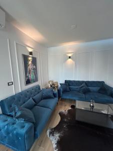een woonkamer met een blauwe bank en een tafel bij Daphne Luxe Retreat -Sea View-King size bed- in Supetar