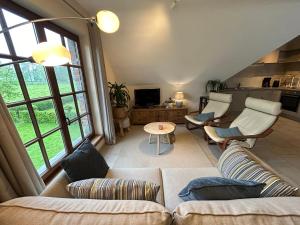 sala de estar con sofá, sillas y TV en Au Coeur des Collines, Gloriette en Ellezelles