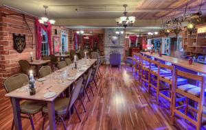 a dining room with tables and chairs and a bar at Manoir Charlevoix in La Malbaie