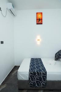 a bedroom with a bed with a picture on the wall at Airport Colombo Pocket Paradise in Seeduwa