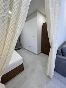 ein Schlafzimmer mit einem Bett, einem Sofa und Vorhängen in der Unterkunft برج ماجيك سويت Magic Suite Tower in Kuwait