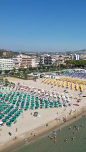 a beach filled with lots of people and umbrellas at Residence Riviera in Alba Adriatica