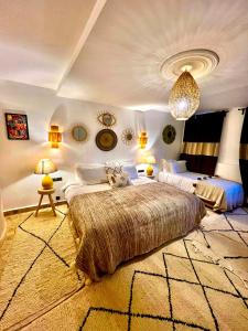 Habitación grande con 2 camas y lámpara de araña. en Riad Sahara Stars Dades en Boumalne