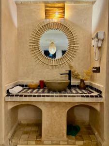 y baño con lavabo y espejo. en Riad Sahara Stars Dades, en Boumalne
