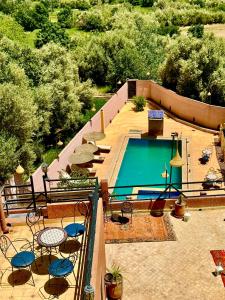 - une vue sur la piscine avec des tables et des chaises dans l'établissement Riad Sahara Stars Dades, à Boumalne