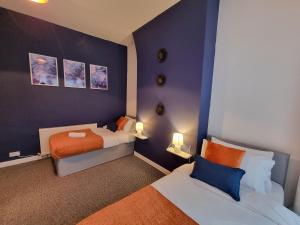 Roomy house near city centre and docks Free parking في ليفربول: غرفة نوم صغيرة بسريرين ومصباحين