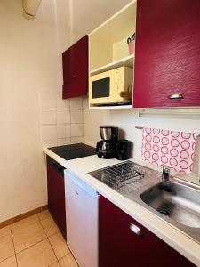 una pequeña cocina con fregadero y microondas en La villa De Lina 508 -Self Check In -, en Gallargues-le-Montueux