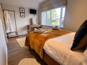 1 dormitorio con 1 cama grande y 2 toallas. en Stunning 3-Bed Cottage in The Forest of Dean en Coleford