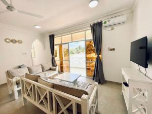 a living room with a couch and a table at Ammerville Diani in Diani Beach