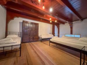 a large room with two beds and a wooden floor at Weeshuis klein in Enkhuizen