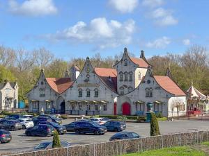 a large building with cars parked in a parking lot at Weeshuis klein in Enkhuizen