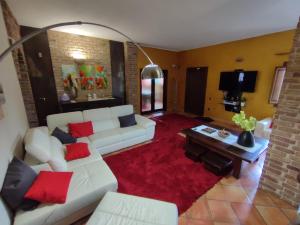 sala de estar con sofá blanco y almohadas rojas en Villa Verde Guest House, en Tramatza
