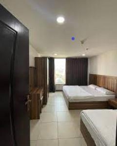 ein Hotelzimmer mit 2 Betten und einem Fenster in der Unterkunft GMR House in Irbid