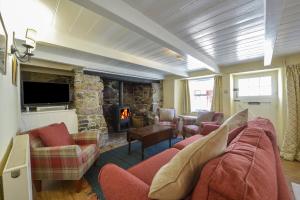 a living room with a couch and a fireplace at April Cottage in Coverack