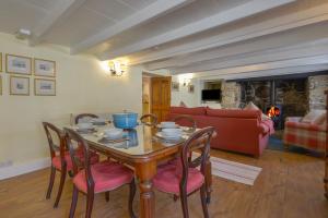 a dining room with a table and chairs and a fireplace at April Cottage in Coverack