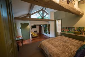 a bedroom with a bed and a large window at Art'Hotel & SPA Le Potin Gourmand in Cluny