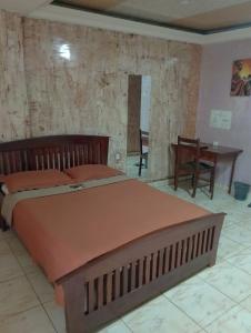 a bedroom with a large bed and a table at CONSTELLATION HOTEL in Dschang