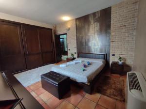 1 dormitorio con 1 cama grande y pared de ladrillo en Villa Verde Guest House, en Tramatza