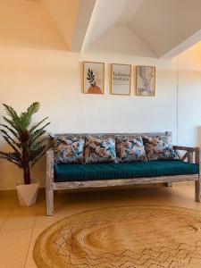 a couch in a living room with a plant at Samara Studio Apartment - Diani Beachfront in Diani Beach