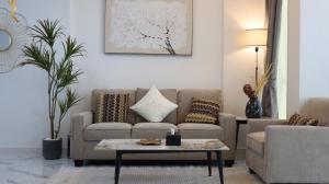 a living room with a couch and a table at Bright 2BR Retreat - Sleek Modern Living in Abu Dhabi