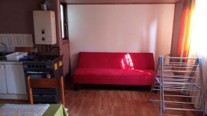 a living room with a red couch and a stove at Cabaña in Valdivia