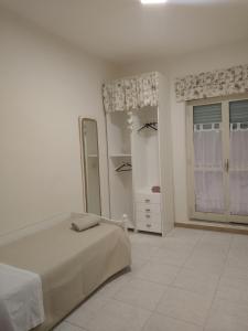 um quarto branco com uma cama e uma janela em Orchidea1 em Marcianise