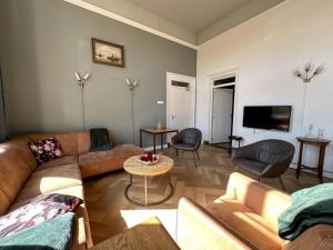 a living room with a couch and a tv at Weeshuis Groot in Enkhuizen