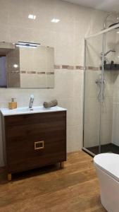 a bathroom with a sink and a glass shower at Ca la Trini Vivienda Vacacional in Nava