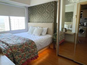 a small bedroom with a bed and a window at Modern 2BR Educity Apartment, Pakuwon City in Surabaya