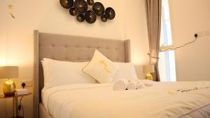 a bedroom with a white bed with towels on it at Lavish 2BR Duplex in Masdar City - Luxe Retreat Near Masdar Park & City Centre in Abu Dhabi +37 photos