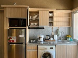 cocina con nevera de acero inoxidable y lavavajillas en Modern 2BR Educity Apartment, Pakuwon City, en Surabaya